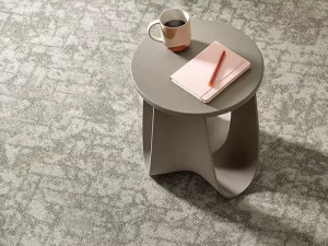 A picture of ShawContract New Path Collection - Upbeat Ecoworx® S carpet tile, with furniture and books on top of it.